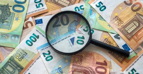 Eurobiljetten met een vergrootglas erboven